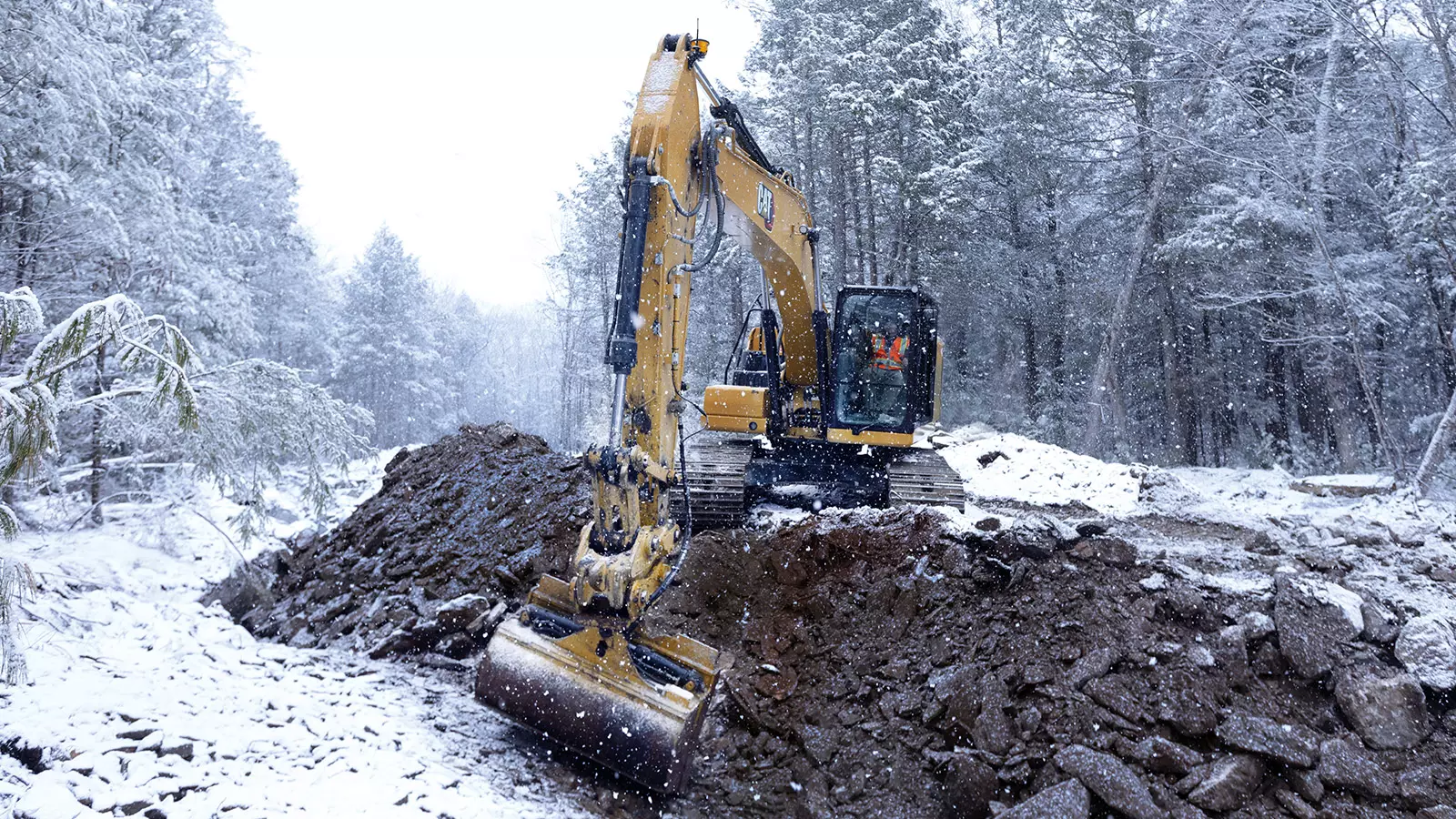 Excavator with tilt bucket using Siteworks Machine Guidance in snow